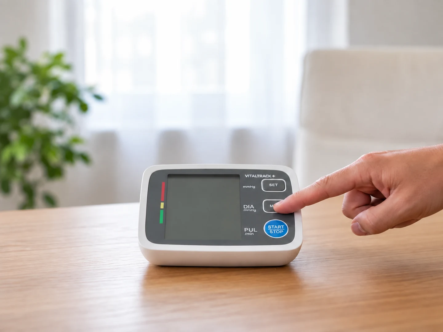 Hand operating the Vitaltrack blood pressure monitor