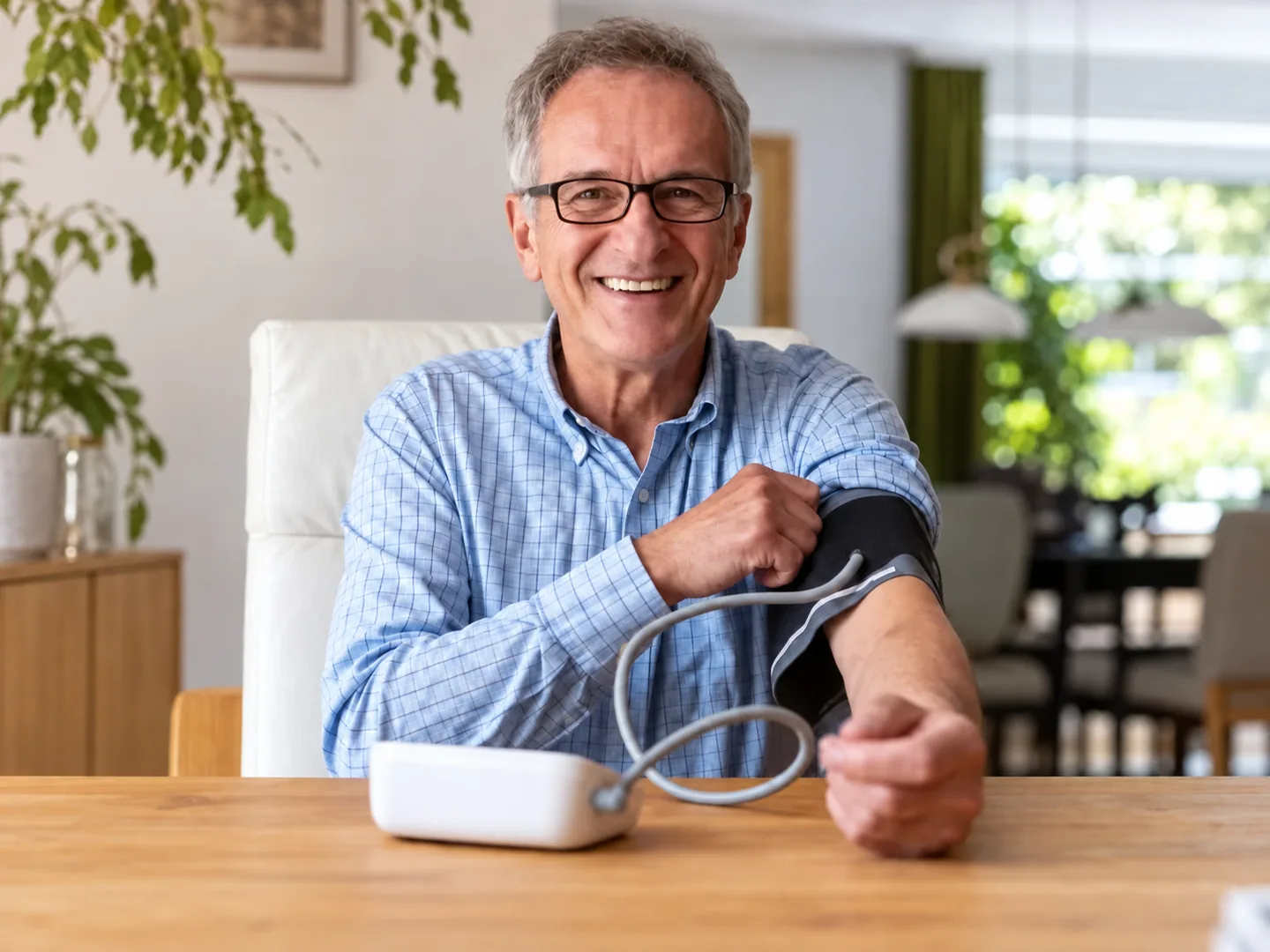 Man smiling after completing a blood pressure measurement at home